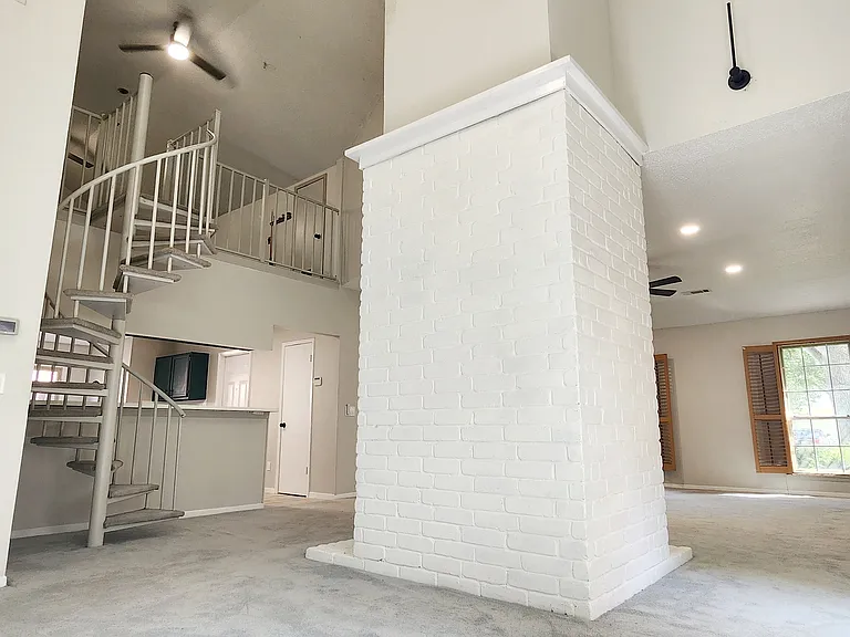 Second living space behind fireplace and door to the side of the house