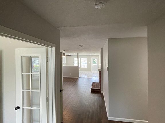 View of living room and kitchen from entryway. Bedroom 1 on the left. Hallway on the right to bedroom 2 and primary bedroom.