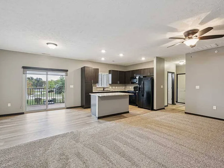 Host, relax, or unwind in this open-concept living area featuring a modern kitchen and private balcony access, designed for every lifestyle.