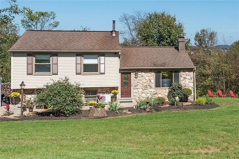 Beautiful curb appeal with enhanced landscaping, including mulch beds, waterfall, and lighting.