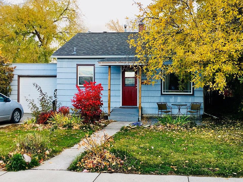 Front of house with apple tree and view of garage and off-street parking. A fence with gates has been added to the front yard.