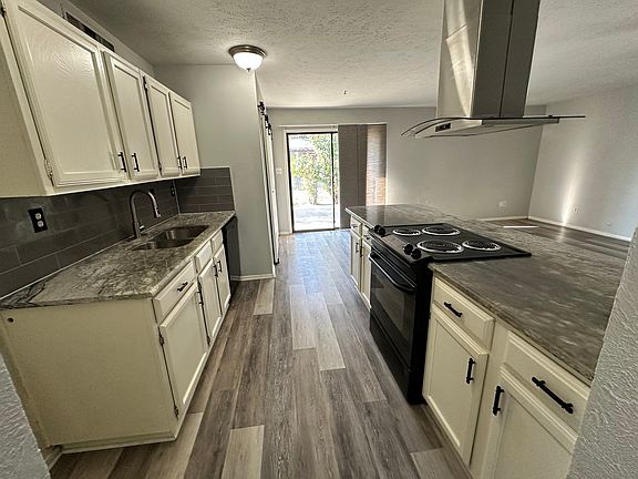 Kitchen with granite countertops, tile backsplash, stainless exhaust and spray sink faucet