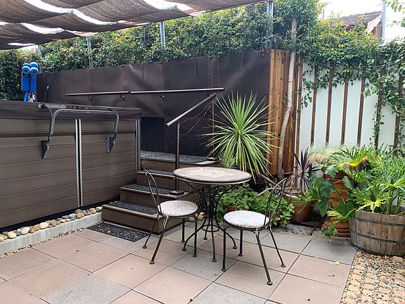 Swim spa patio with retractable sunshade.