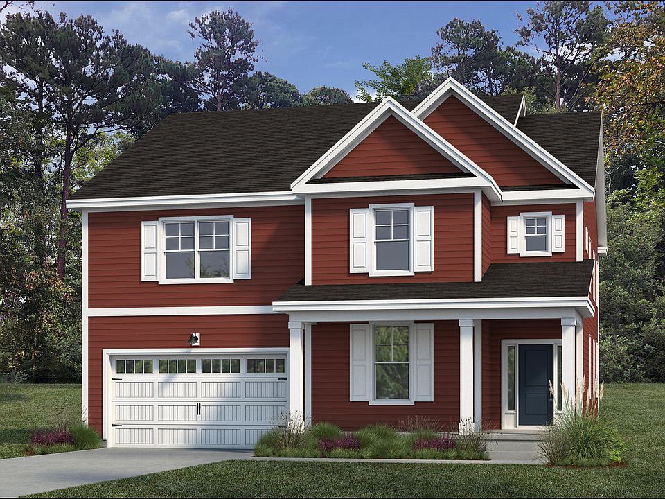 A red two-story house with white trim, a dark roof, a two-car garage, and a small covered front porc