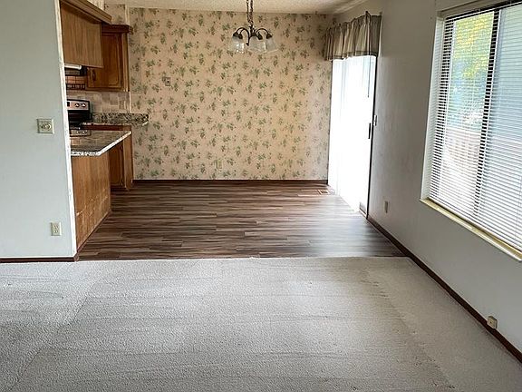 Living room looking into dining area with balcony overlooking backyard