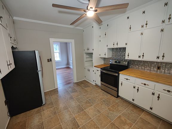 Large kitchen with lots of cabinets and stainless steel appliances