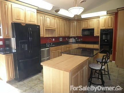 Kitchen : Custom built with natural hickory. Granite countertops. Double oven.