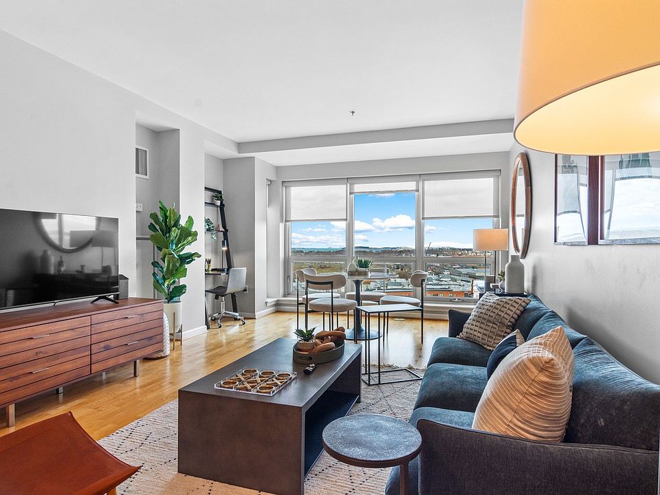 Living room flooded with natural light at The Amelia Apartments in Quincy, MA