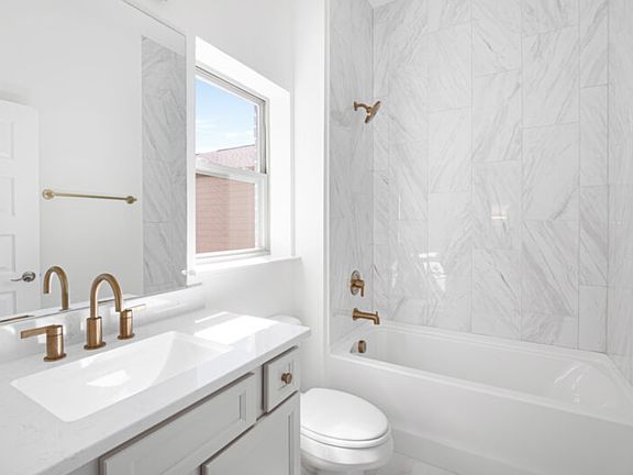 The primary bathroom offers a compact, functional design with a bathtub, toilet, and sink.