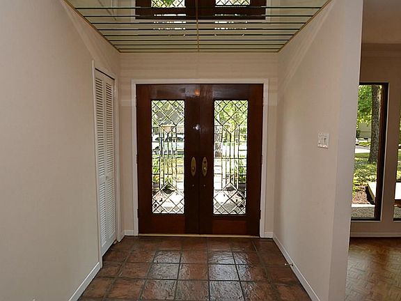 Elegant entry with double beveled glass front doors, tile flooring, mirror accents and access to a h