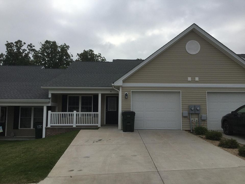 Front view of home with sitting porch & attached garage with garage door opener.