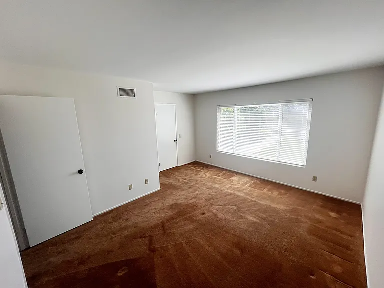Master bedroom with large window facing backyard.