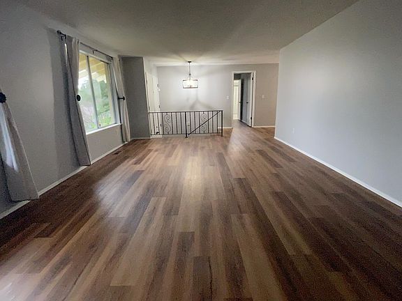 Living Room looking toward entry. New flooring, new light fixtures, new curtains.