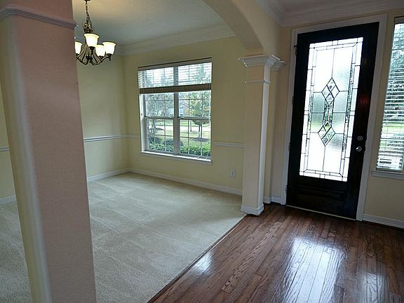 Elegant entry with leaded glass front door  and hardwood floors.   Columns and pilars separate the entry from the formal dining room.