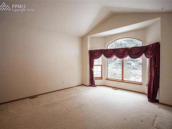 Living room on main floor with vaulted ceilings and large open windows.
