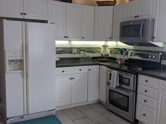 Fully equipped kitchen,Has a side by side fridge with purified water, double oven/range hood microwave, sink with garbage disposer, dishwasher, sliding door going out to the deck. White farm table seat 4-6.