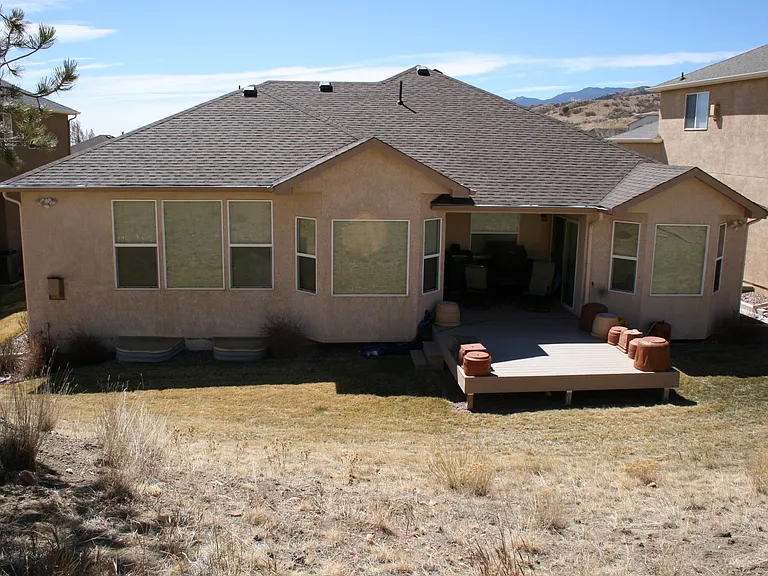 Back of house. Raised patio. Note: Empty clay pots upside down for the winter on the patio.