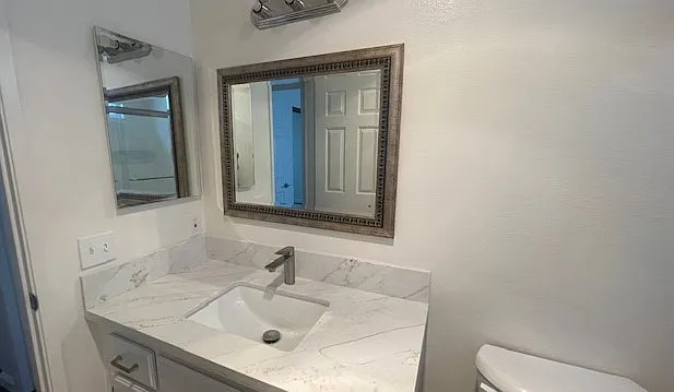 Guest bathroom with new granite countertop and fixtures.
