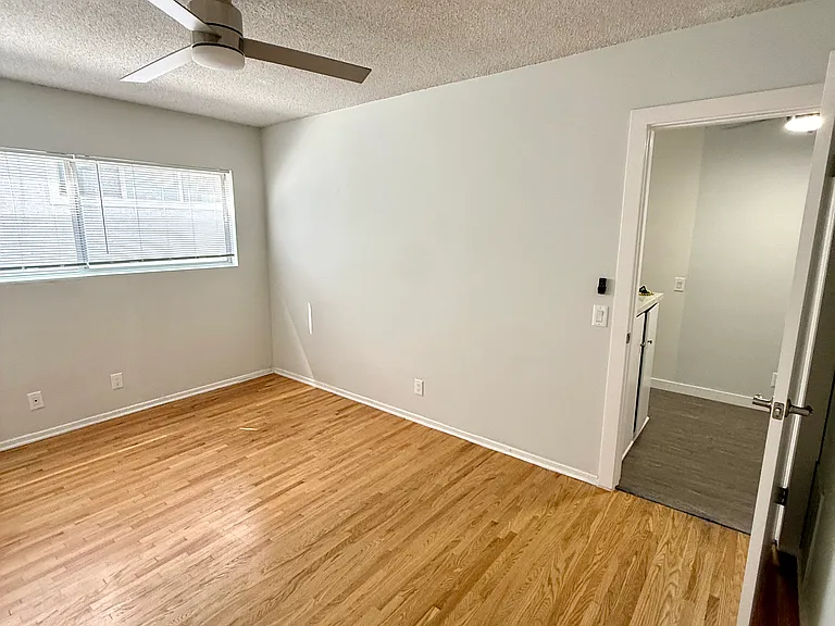 View of the bedroom and doorway leading to the kitchen and living room.