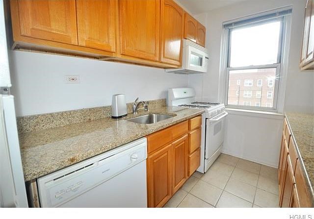 Spacious kitchen with tile floors and dining counter.