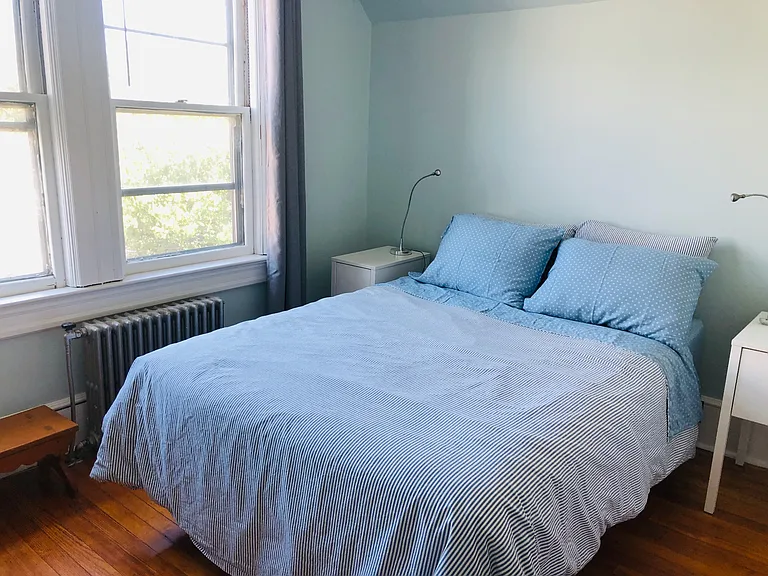North facing back bedroom. Full size bed, 2 bedside tables, lovely vintage dresser, easy chair, ceiling fan, closet