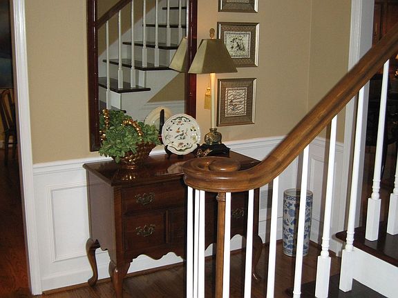 Foyer with open solid wood staircase.