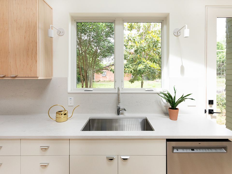 Large kitchen windows, deep stainless steel sink with Grohe faucet and Cosentino Quarts counter and splash.