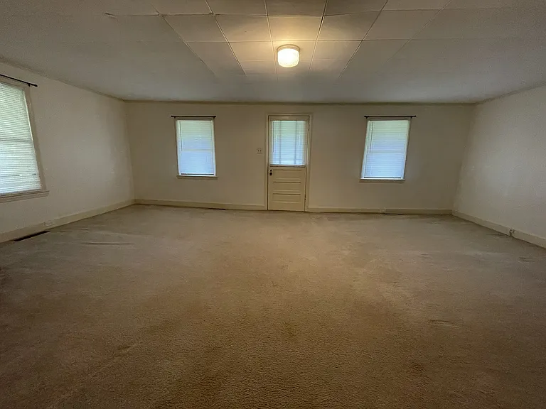 Large room across front of home with windows facing east, south and west