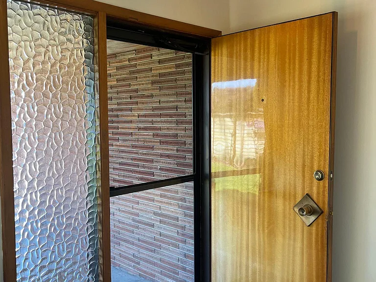 Front door with new screen door and light fixture.