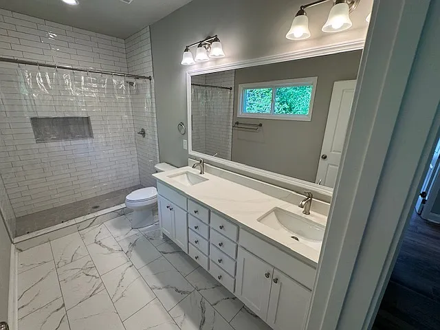 Primary Ensuite with Double Vanities, custom cabinetry with Quartz Countertops, Ceramic Tile Shower and Flooring