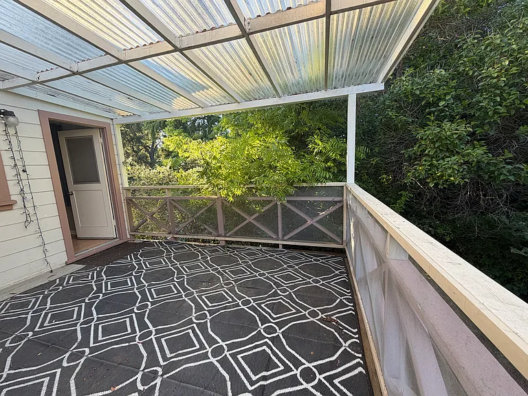 This view is from the patio looking toward the upstairs bedroom door. There is plenty of room for furniture, a table, or freestanding hammock.