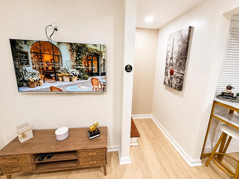 Common-area nook with mounted TV, media console, and adjacent bar-style counter seating for lounging or quick meals.
