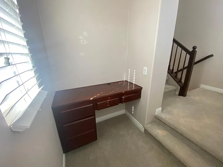 Bonus area with desk by the stairs. Not could function as a small office.