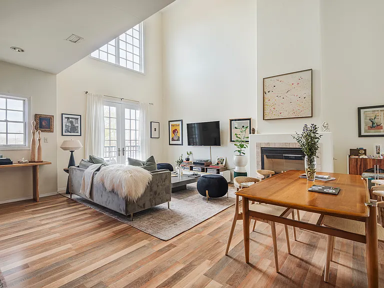 Second-floor living area featuring a fireplace, abundant natural light, and large windows.