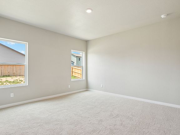 The master bedroom is spacious with two large windows.