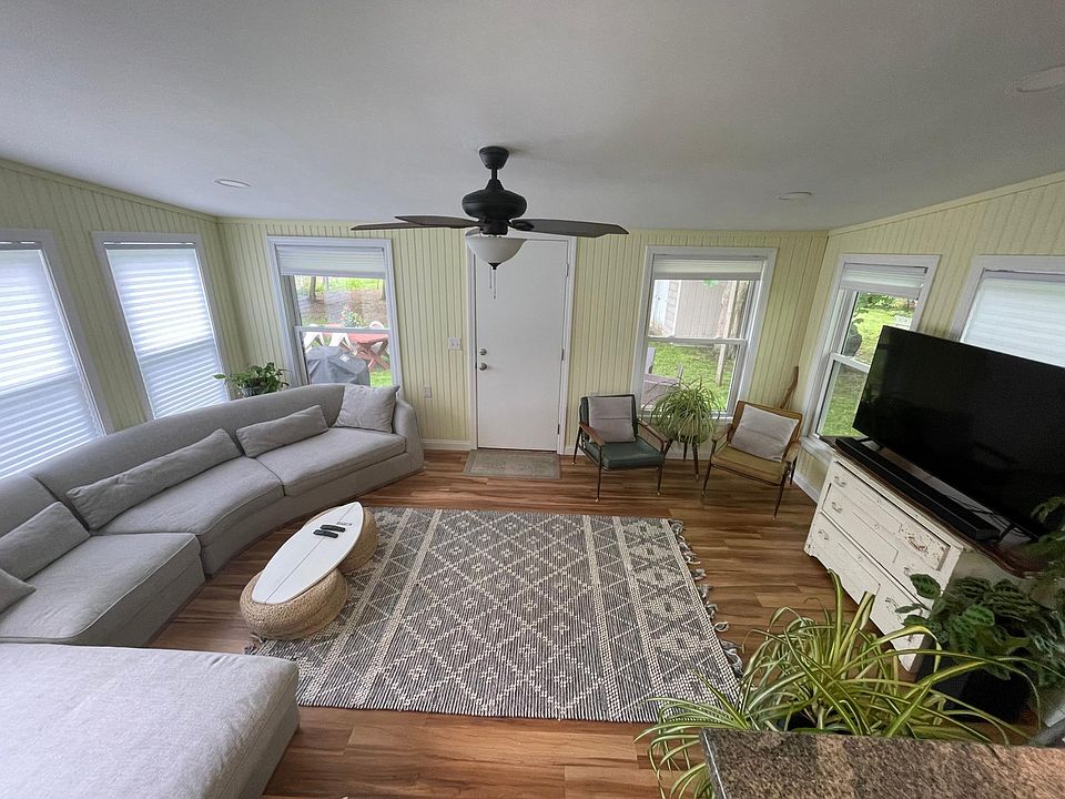 Living room, open to kitchen and includes backdoor to patio, large windows, very sunny and bright