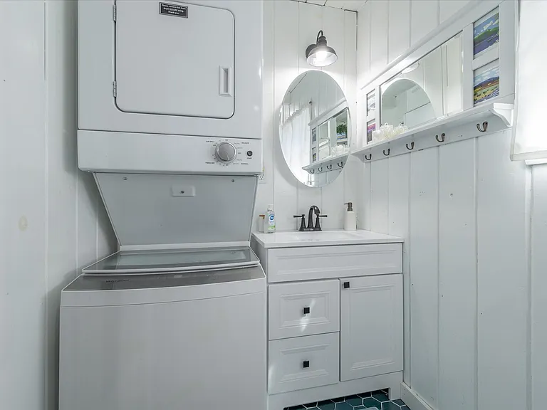 Bathroom with walk-in shower / shares space with washer / dryer.