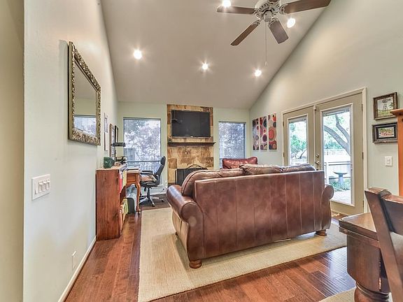 Living Area With Updated Fireplace Surround, High Ceilings With Recessed Lighting and Access To The Patio Area.