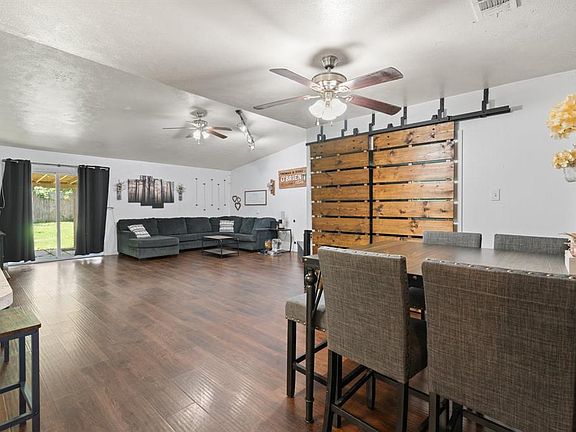 Dining space with vaulted ceiling, a ceiling fan, and wood finished floors