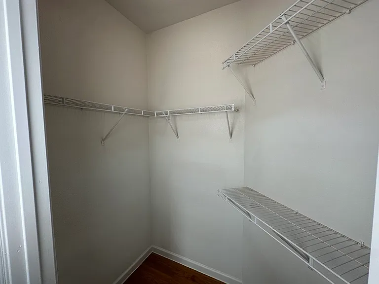 Spacious walk-in closet with ample shelving and storage space. Spacious walk-in closet with ample shelving and storage space.