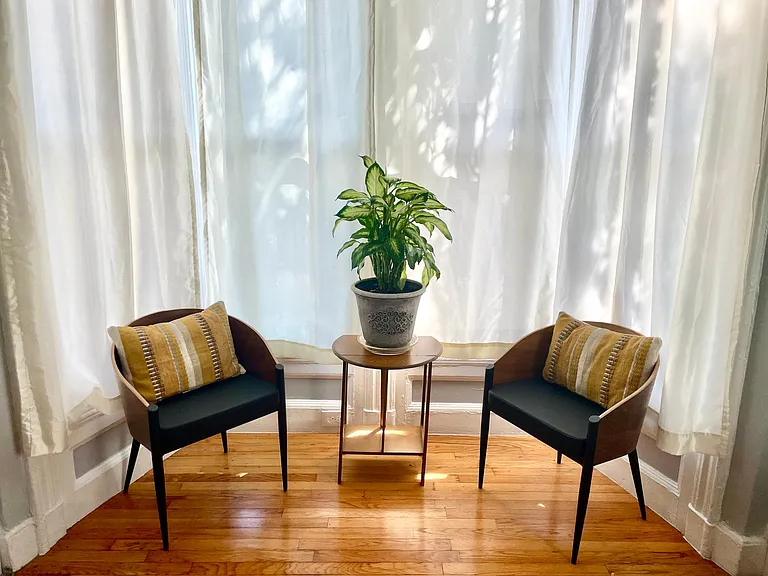 Bright bay window sitting area overlooking a quiet residential street