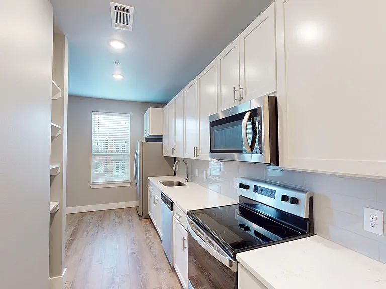 The Railyard kitchen includes a lot of cabinet space, custom shelving, and stainless steel appliances, including a glass-top stove, microwave, dishwasher, and refrigerator. The Railyard kitchen includes a lot of cabinet space, custom shelving, and stainle