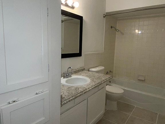 Hall Bathroom with Built In's, Ceramic Tile Flooring & Tiled Tub Surround.