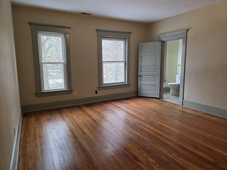 View from the fireplace in the master bedroom, looking at the front windows and bathroom door.
