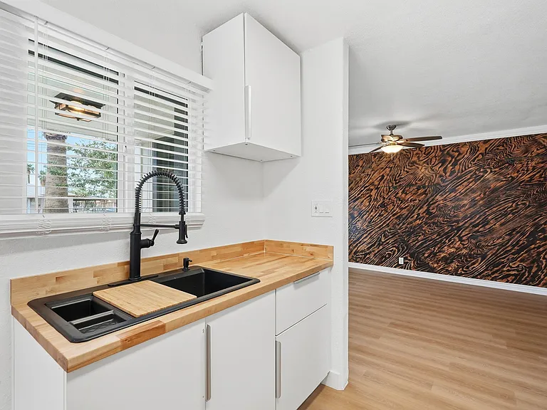 Large window above farm house sink with view to the east and to front entrance of unit.