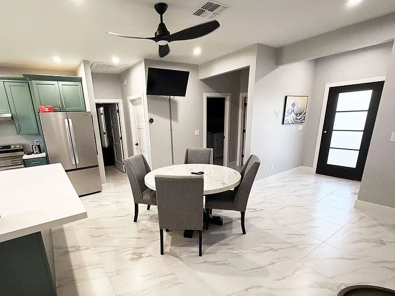 Open dining area beside the kitchen with a round table, tile flooring, and easy flow to adjacent rooms