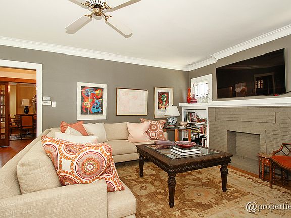 Open Living Room with Fireplace Leads to Sunroom