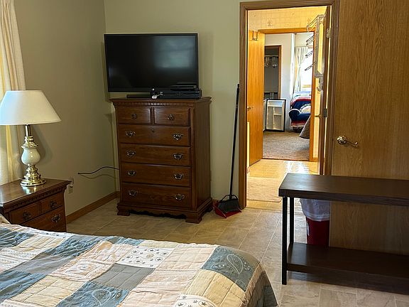 45" flat screen television with DVD Player, dresser, and door to bathroom