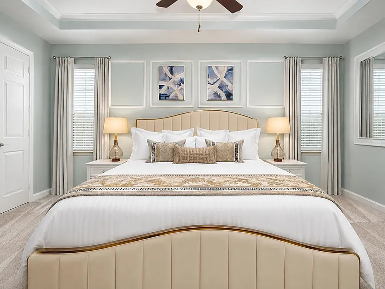Spacious bedroom with a large bed, two windows with blinds and drapery, and matching nightstands with lamps.