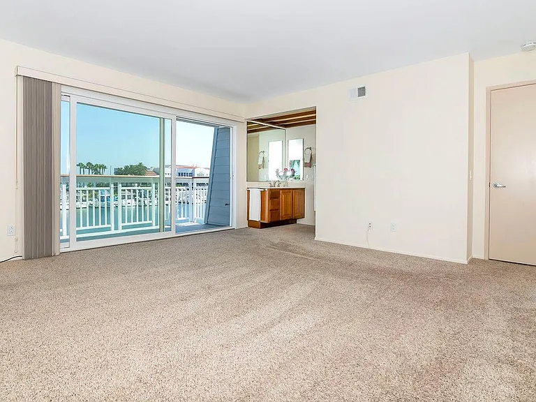 Master bedroom (upstairs) with sliding glass door & balcony view overlooking marina and San Diego bay.